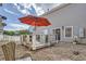 Backyard deck featuring a grill, table, seating, and an orange umbrella with a stone ground covering at 11832 Zenobia Loop, Westminster, CO 80031