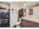 Modern bathroom features a custom vanity, round mirror, and closet with shoe storage at 11832 Zenobia Loop, Westminster, CO 80031