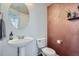 Stylish half-bathroom featuring a modern vanity, decorative copper wall, and a unique round mirror at 11832 Zenobia Loop, Westminster, CO 80031