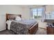 Bedroom with large window, wooden bed frame and adjacent flatscreen television at 11832 Zenobia Loop, Westminster, CO 80031