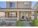 Charming home facade with a covered front porch, seating, attractive landscaping, and the house number at 11832 Zenobia Loop, Westminster, CO 80031