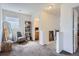 Hallway with access to a carpeted bedroom and bathroom, a full length mirror and a chair at 11832 Zenobia Loop, Westminster, CO 80031