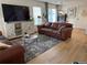 Inviting living room featuring a plush leather sofa, stylish rug, and bright natural light at 11832 Zenobia Loop, Westminster, CO 80031