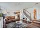 Open living room with staircase, hardwood floors, an adjacent dining area, and neutral walls at 11832 Zenobia Loop, Westminster, CO 80031