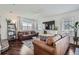 Inviting living room featuring hardwood floors, a modern entertainment center, and ample natural light at 11832 Zenobia Loop, Westminster, CO 80031