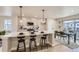 Open-concept kitchen featuring a large island with seating, pendant lighting, stainless steel appliances, and an adjacent dining area at 128 E Douglas St, Superior, CO 80027