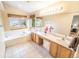 Bright bathroom with double sinks, soaking tub, large windows, and tile flooring for a spa-like retreat at 6118 Salvia Ct, Arvada, CO 80403