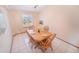 Cozy dining area with tile flooring, wood table with four chairs, and a sunny window at 6118 Salvia Ct, Arvada, CO 80403