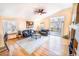 Bright living room boasts vaulted ceilings, hardwood floors, a ceiling fan, and access to the outdoor deck at 6118 Salvia Ct, Arvada, CO 80403