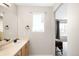 Well-lit bathroom with vanity, sink, and window offering lots of natural light at 9481 Longstone Dr, Parker, CO 80134