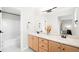 Spacious bathroom with double sinks, wooden cabinets, and a connecting door to the shower/tub at 9481 Longstone Dr, Parker, CO 80134