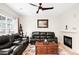 Comfortable living room with leather sofas, ceiling fan, fireplace and large window providing natural light at 9481 Longstone Dr, Parker, CO 80134