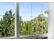 A window with view of lush trees and neighborhood buildings beyond under a clear blue sky at 9481 Longstone Dr, Parker, CO 80134