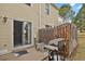 Outdoor patio area with a sliding glass door, propane grill, and partially fenced yard for outdoor enjoyment at 8879 W Floyd Ave, Lakewood, CO 80227