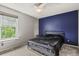 Comfortable bedroom showcasing a dark accent wall, soft carpeting, and a bright window for natural light at 8879 W Floyd Ave, Lakewood, CO 80227