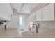 Well-lit kitchen with white cabinets, updated countertops, and a view of laundry area at 8879 W Floyd Ave, Lakewood, CO 80227