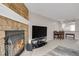 Inviting living room with stone fireplace, TV, and an open view to the dining area at 8879 W Floyd Ave, Lakewood, CO 80227
