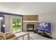 Living room featuring a stone fireplace, sliding glass doors, and a large television at 8879 W Floyd Ave, Lakewood, CO 80227