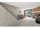Living room featuring a stone fireplace, sliding glass doors, and access to the staircase at 8879 W Floyd Ave, Lakewood, CO 80227