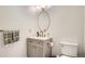 Elegant half-bathroom with a vanity, toilet, brushed gold hardware, and decorative mirror at 6494 W 85Th Ave, Arvada, CO 80003