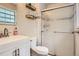 Clean bathroom with white subway tile, glass shower, vanity with sink, and floating wood shelves at 6494 W 85Th Ave, Arvada, CO 80003