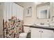 Traditional bathroom with a floral shower curtain, toilet, and vanity with a sink at 6494 W 85Th Ave, Arvada, CO 80003