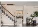 Inviting foyer featuring a staircase with decorative carpet, hardwood floors, and an entry to the living room at 6494 W 85Th Ave, Arvada, CO 80003