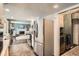 Modern kitchen with stainless steel appliances, tile flooring, and open to a living room with a fireplace at 6494 W 85Th Ave, Arvada, CO 80003