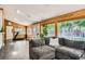 Living area/sunroom featuring a large sectional sofa, wood paneling, and natural light at 6494 W 85Th Ave, Arvada, CO 80003