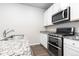 Well-lit kitchen features stainless steel appliances, granite countertops, and wood-look floors at 42741 Ivydel Cir, Elizabeth, CO 80107