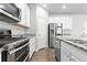 Well-equipped kitchen featuring modern appliances, granite countertops, white cabinetry, and wood-style flooring at 42741 Ivydel Cir, Elizabeth, CO 80107