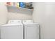 Bright laundry room features white appliances, overhead shelving, and neutral paint at 42741 Ivydel Cir, Elizabeth, CO 80107