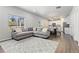 Open-concept living and dining area with a gray sectional sofa, hardwood floors, and plenty of natural light at 42741 Ivydel Cir, Elizabeth, CO 80107