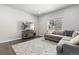 Cozy living room features a comfortable gray sectional sofa, large patterned rug, and a modern entertainment center at 42741 Ivydel Cir, Elizabeth, CO 80107