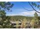 Scenic view of tree-covered mountains and blue skies seen from behind residential rooftops and tree branches at 31270 John Wallace Rd # 310, Evergreen, CO 80439