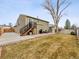 Backyard with deck, patio, lawn, mature trees, and exterior storage shed at 4182 S Bahama St, Aurora, CO 80013