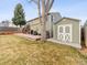 View of the backyard, exterior storage shed, patio, lawn, and mature trees at 4182 S Bahama St, Aurora, CO 80013