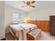 Comfortable bedroom with a ceiling fan, window, and wooden paneled wall at 4182 S Bahama St, Aurora, CO 80013