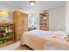 Cozy bedroom featuring carpet, window, a lamp, and shelving for storage at 4182 S Bahama St, Aurora, CO 80013