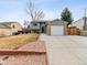 Charming two-story home with attached garage, a well-kept lawn, and red rock landscaping accents at 4182 S Bahama St, Aurora, CO 80013