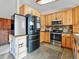 Kitchen featuring stainless steel appliances, light wood cabinets, dark countertops, tile backsplash, and tiled floors at 4182 S Bahama St, Aurora, CO 80013