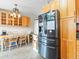 Kitchen nook featuring light wood cabinets, tile floors, chandelier, and stainless steel refrigerator at 4182 S Bahama St, Aurora, CO 80013