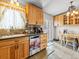 Bright kitchen featuring light wood cabinets, tile floors and backsplash, stainless steel appliances, and backyard access at 4182 S Bahama St, Aurora, CO 80013