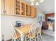 Cozy kitchen nook with light wood cabinets, tile floors, chandelier, and a view into the living room at 4182 S Bahama St, Aurora, CO 80013