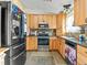Well-lit kitchen featuring light wood cabinets, stainless steel appliances, and tile floors and backsplash at 4182 S Bahama St, Aurora, CO 80013