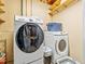 Bright laundry room features modern Samsung washer and dryer with convenient shelving for storage at 4182 S Bahama St, Aurora, CO 80013