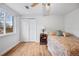 Bright bedroom with ceiling fan, window, and sliding door to closet at 7636 S Eaton Way, Littleton, CO 80128