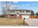 Ranch style home with brick and siding exterior, attached garage, and landscaped yard at 7636 S Eaton Way, Littleton, CO 80128