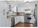 White kitchen with stainless steel appliances and ample counter space at 7636 S Eaton Way, Littleton, CO 80128