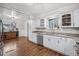 Spacious kitchen featuring white cabinets, stainless steel dishwasher, and hardwood floors at 7636 S Eaton Way, Littleton, CO 80128